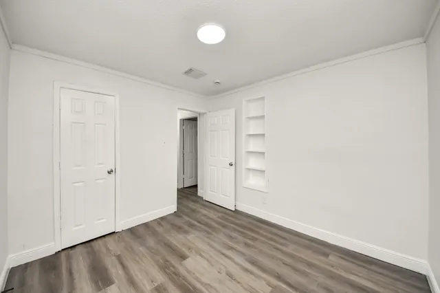 a view of empty room with wooden floor