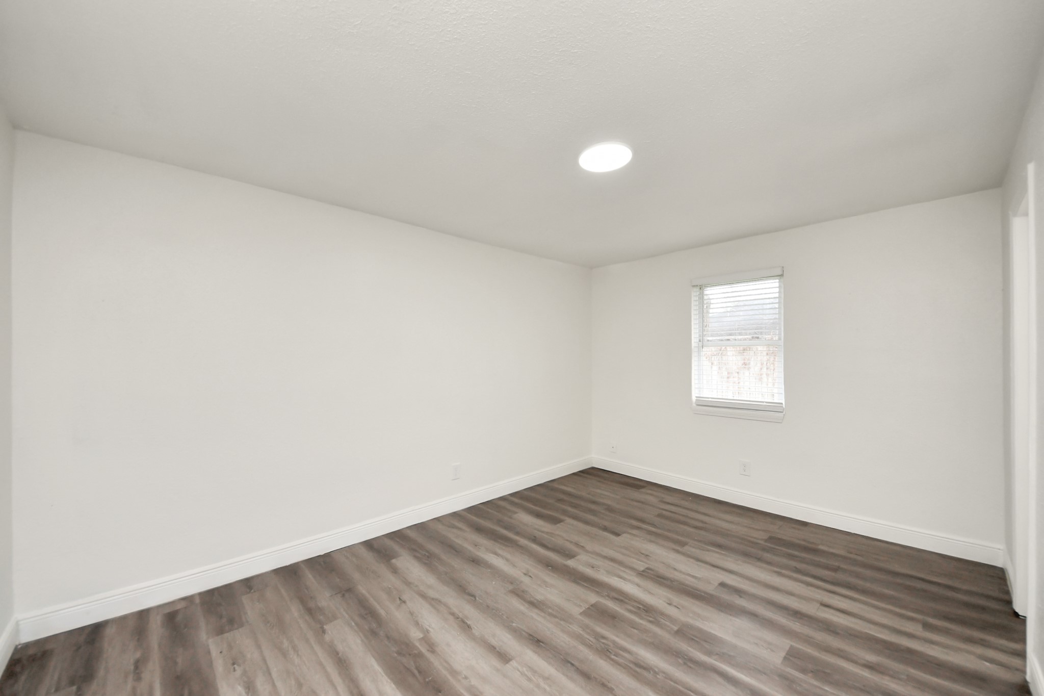 1139 Hartwick Road Houston, TX 77037 - Photo 33 of 38 an empty room with wooden floor and windows
