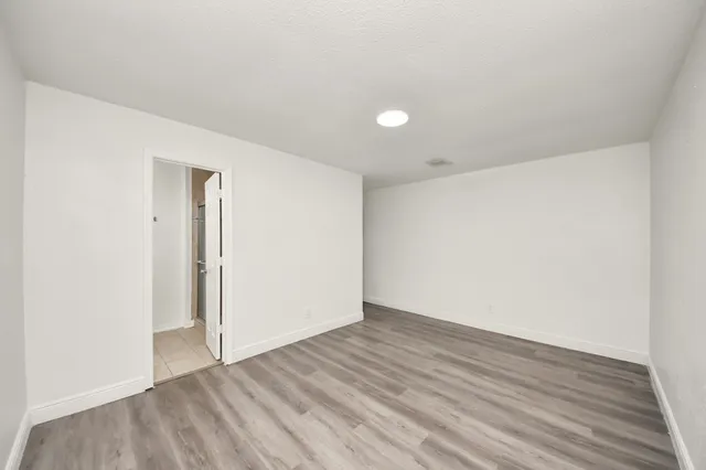 a view of an empty room with wooden floor