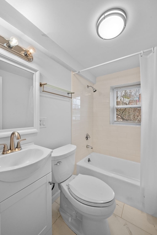 121 Cambridge Road, Unit 2 Woburn, MA 01801 - Photo 15 of 23 a white toilet sitting next to a bathroom sink