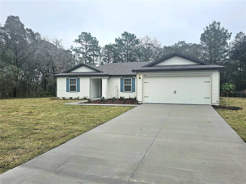 a view of a white house with a yard and plants