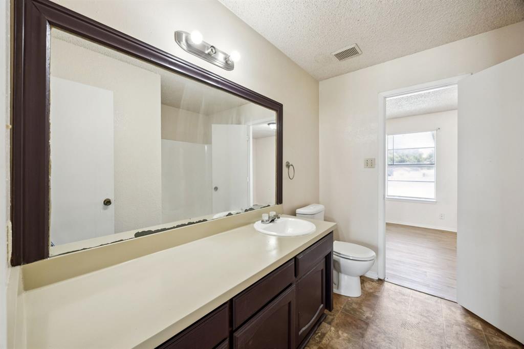 7504 Chapin Road Fort Worth, TX 76116 - Photo 18 of 30 a bathroom with a sink a toilet and mirror