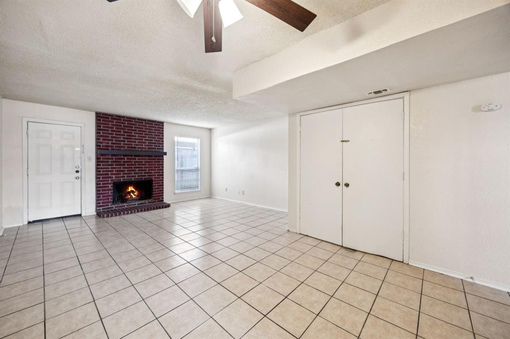 7504 Chapin Road Fort Worth, TX 76116 - Photo 3 of 30 a view of an empty room with a fireplace and a chandelier fan
