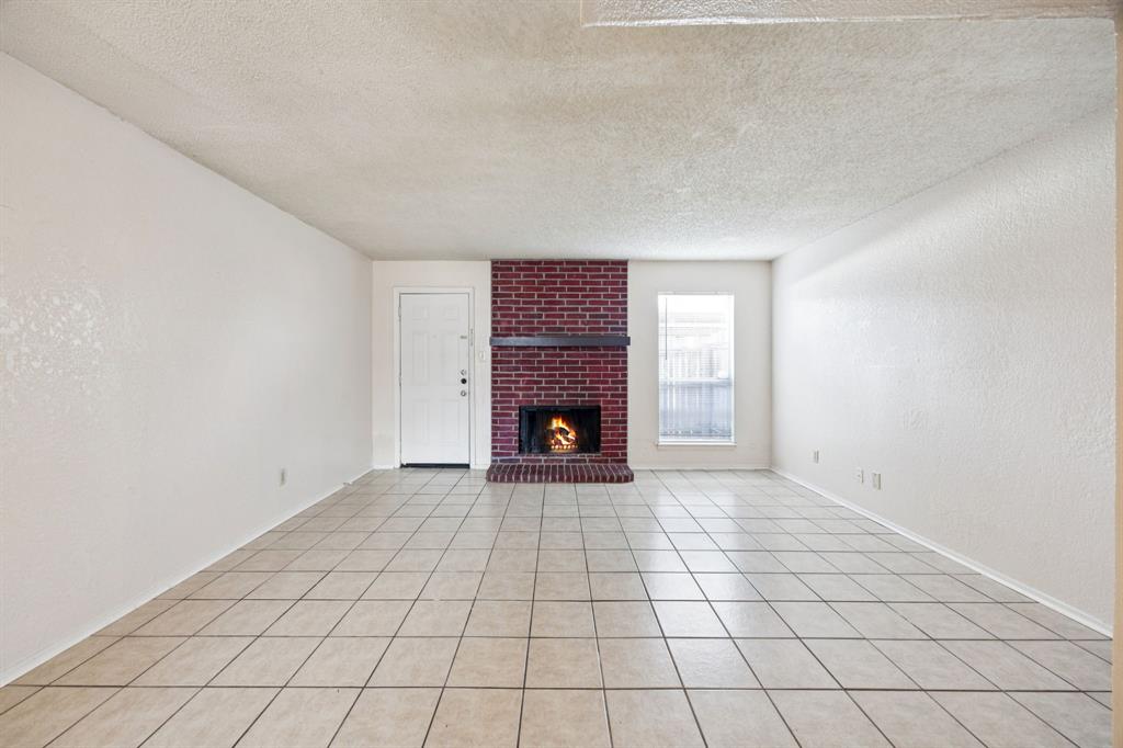 7504 Chapin Road Fort Worth, TX 76116 - Photo 6 of 30 a view of an empty room with a fireplace and a window