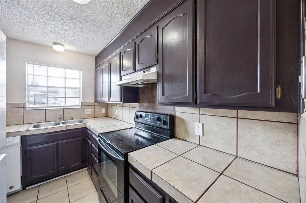 7504 Chapin Road Fort Worth, TX 76116 - Photo 8 of 30 a kitchen that has a sink and a stove in it