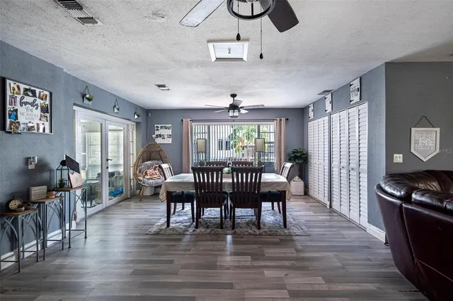 a dining room with furniture a chandelier and wooden floor