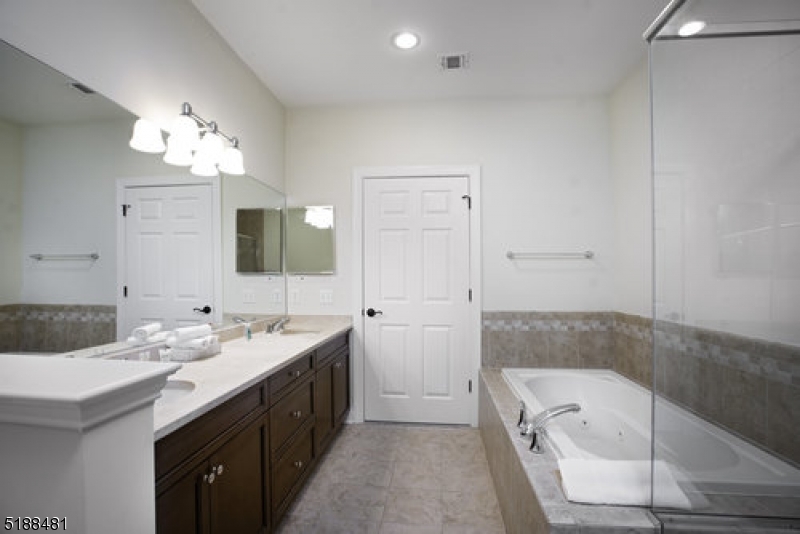 545 Morris Avenue, Unit 219 Summit, NJ 07901 - Photo 4 of 8 a bathroom with a tub sink and mirror