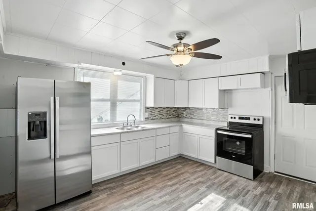 a kitchen with stainless steel appliances granite countertop a stove a refrigerator and a sink