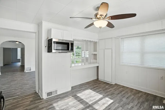 a view of empty room with wooden floor and ceiling fan