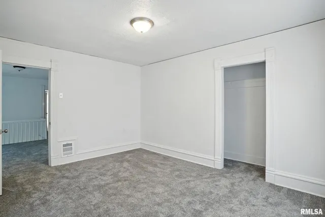 an empty room with windows and closet