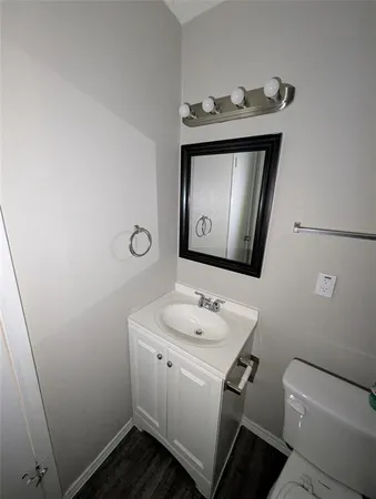 a bathroom with a toilet sink vanity and mirror