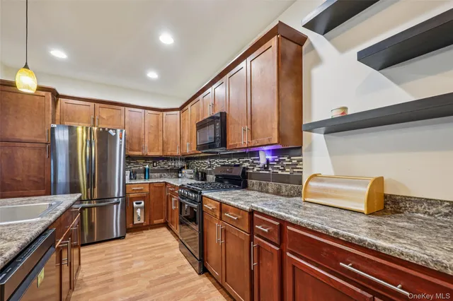 a kitchen with stainless steel appliances granite countertop a sink stove and refrigerator
