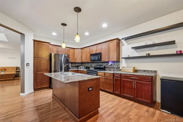 a kitchen with stainless steel appliances granite countertop a sink a stove and a refrigerator