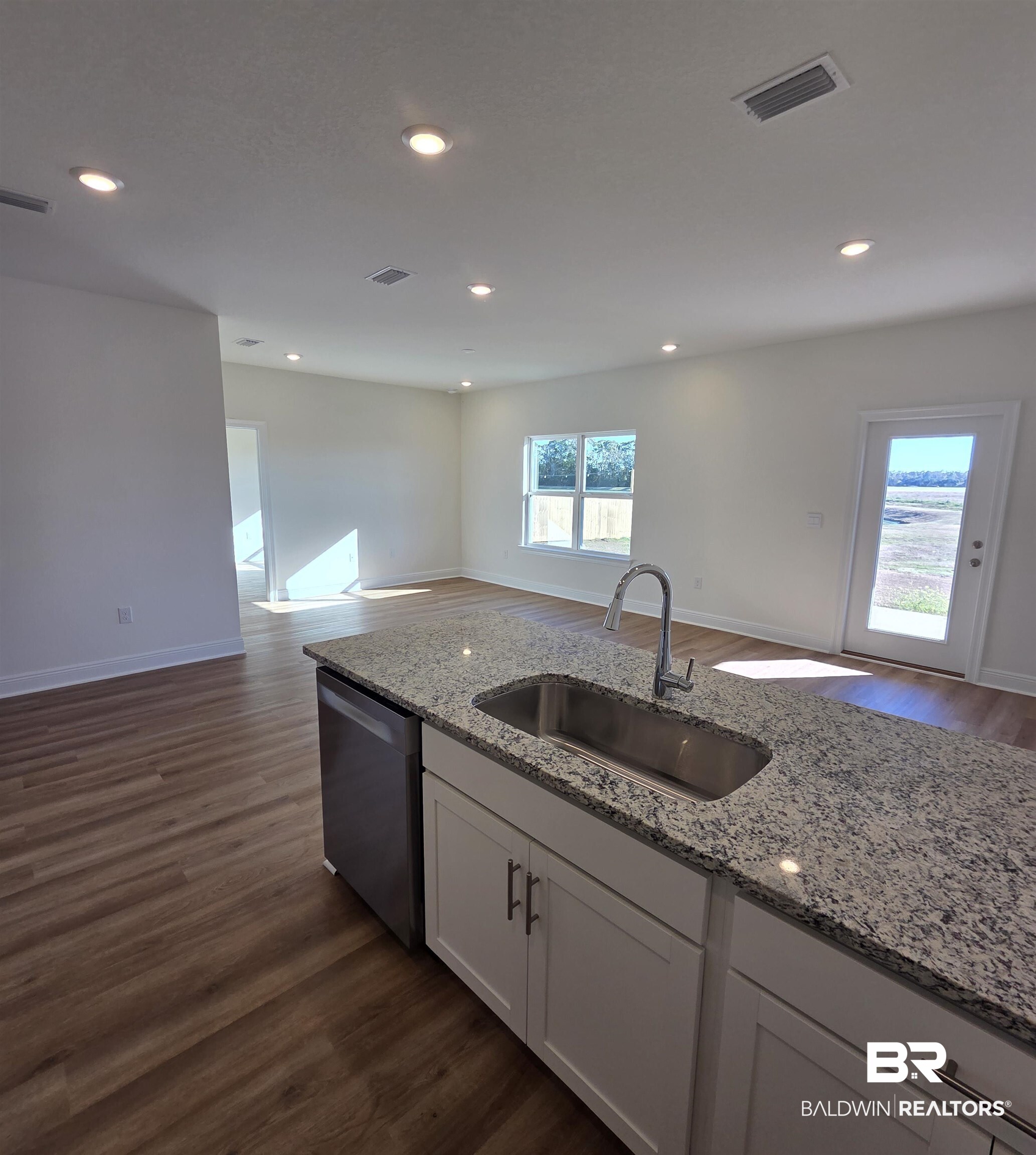 28084 Hallow Trail Elberta, AL 36530 - Photo 19 of 21 Kitchen with dark wood-style floors, open floor plan, white cabinetry, light stone counters, and recessed lighting