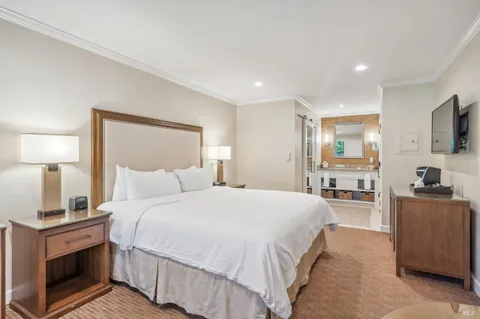 a spacious bedroom with a bed and a flat screen television