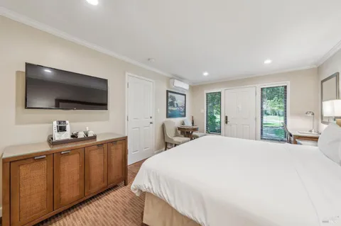 a spacious bedroom with a bed and a flat screen tv