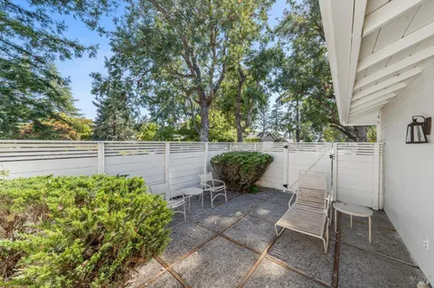 a backyard of a house with table and chairs and potted plants