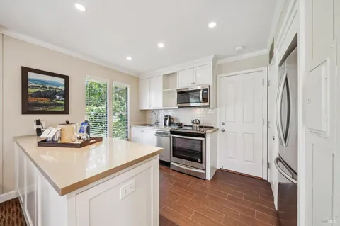 a kitchen with stainless steel appliances kitchen island granite countertop a sink stove and refrigerator