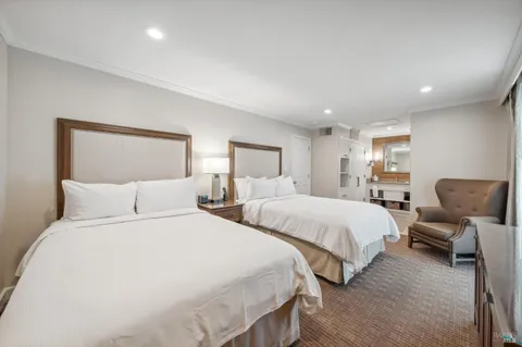 a bedroom with two beds and a chair