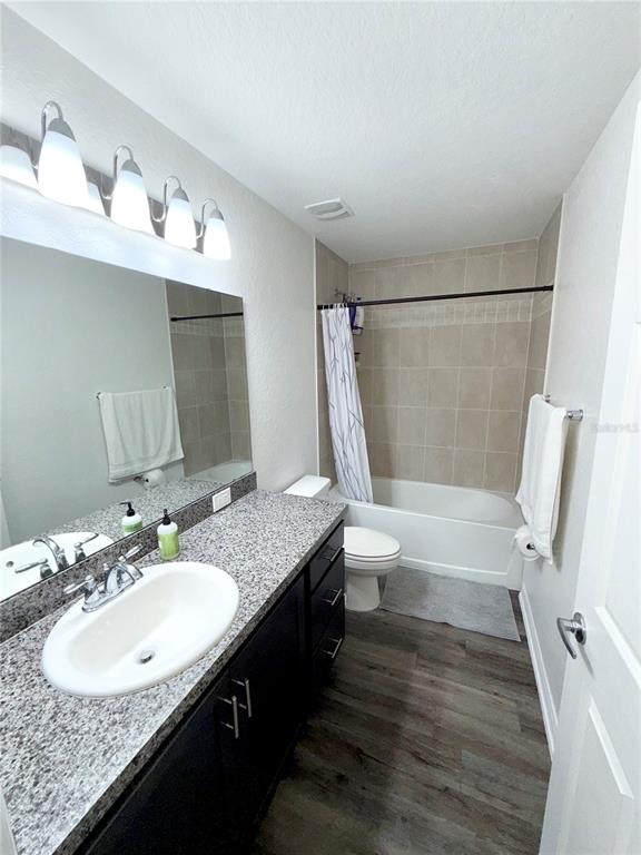 4448 Reding Way Lakeland, FL 33813 - Photo 17 of 26 a bathroom with a granite countertop sink toilet and shower