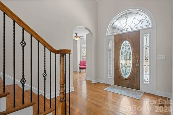 a living room with furniture a large window and wooden floor