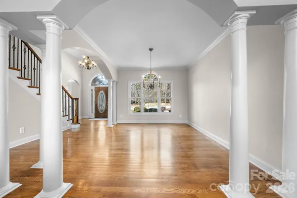 a view of a livingroom with furniture wooden floor windows and a chandelier