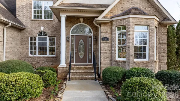 a front view of a house with a lots of flower plants