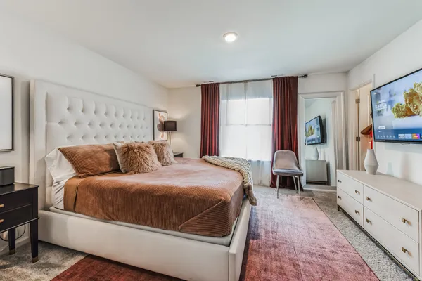 a bed sitting in a spacious bedroom next to a window