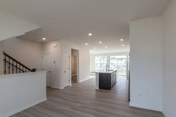 a kitchen with stainless steel appliances granite countertop a refrigerator a sink a stove a microwave and wooden floor