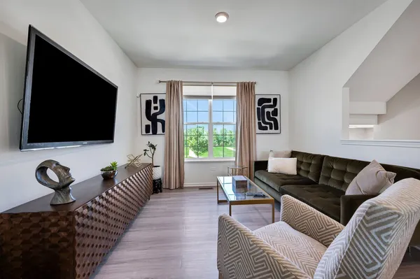 a living room with stainless steel appliances kitchen island granite countertop furniture and a wooden floor