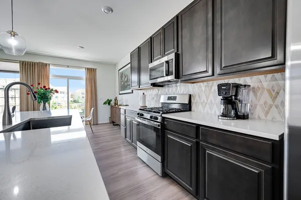 a kitchen with stainless steel appliances granite countertop a sink stove and refrigerator