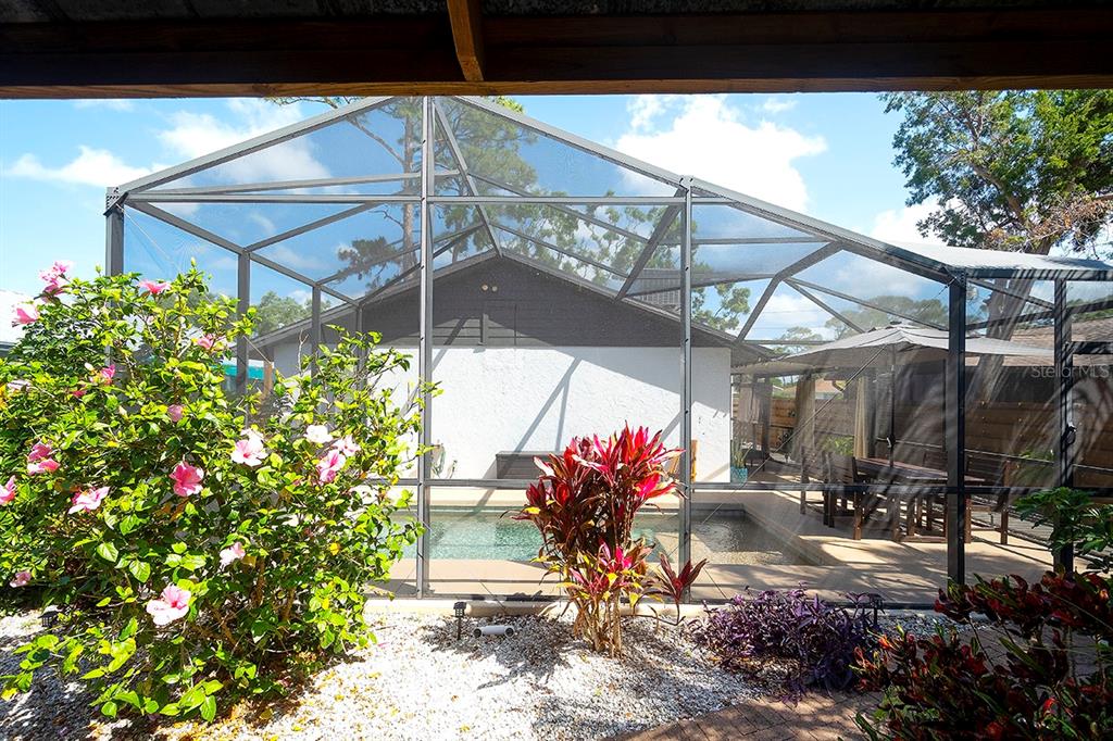 2224 Eugene Street Sarasota, FL 34231 - Photo 32 of 45 a view of a porch with dining table and chairs under an umbrella