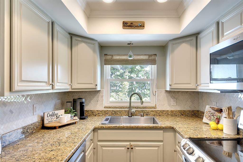 2224 Eugene Street Sarasota, FL 34231 - Photo 10 of 45 a kitchen with stainless steel appliances granite countertop a sink a stove and cabinets