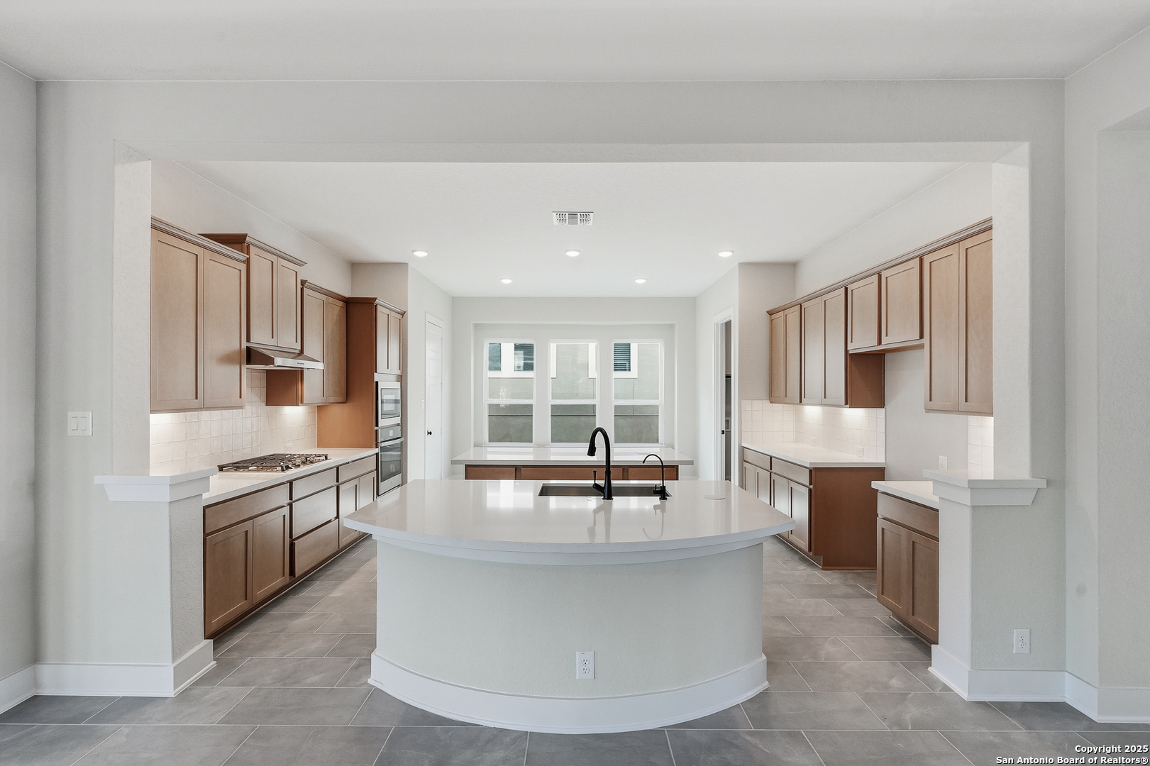 233 Sasparilla Boerne, TX 78006 - Photo 16 of 60 a living room with stainless steel appliances furniture a rug and a kitchen view
