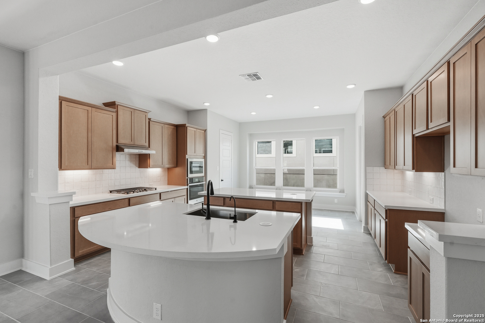 233 Sasparilla Boerne, TX 78006 - Photo 17 of 60 a kitchen with stainless steel appliances granite countertop a sink a stove and a refrigerator