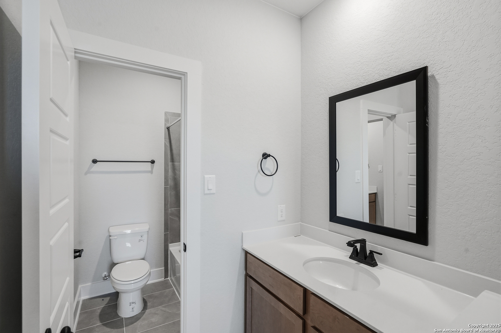 233 Sasparilla Boerne, TX 78006 - Photo 39 of 60 a bathroom with a granite countertop sink a toilet and a mirror
