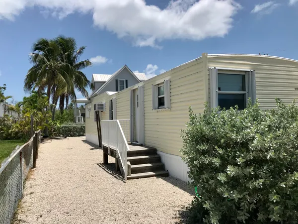 a white house with a large window and potted plants