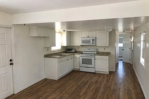 a kitchen with white cabinets and white appliances