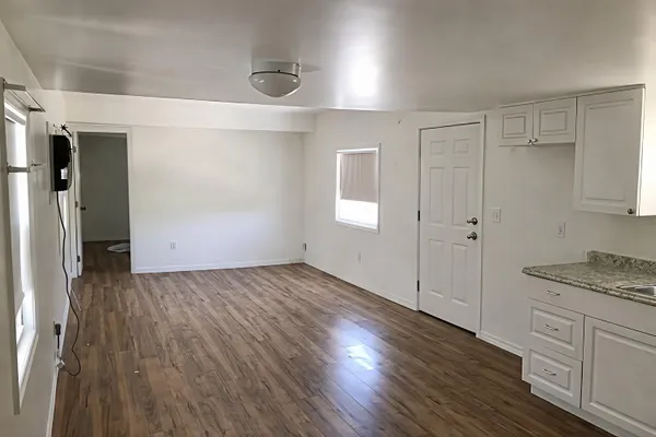 a view of a kitchen with wooden floor and electronic appliances
