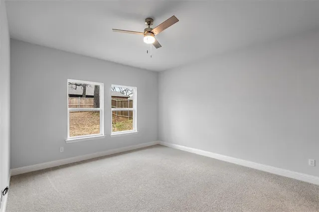 an empty room with chandelier fan
