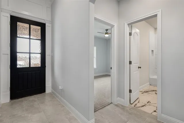 a kitchen with stainless steel appliances granite countertop a sink a stove a refrigerator and white cabinets