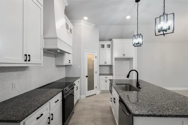 a kitchen that has a lot of cabinets and wooden floor
