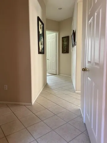 a view of a hallway with wooden floor and a bathroom