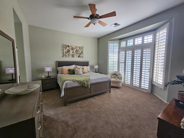 a spacious bedroom with a bed a couch and a large window