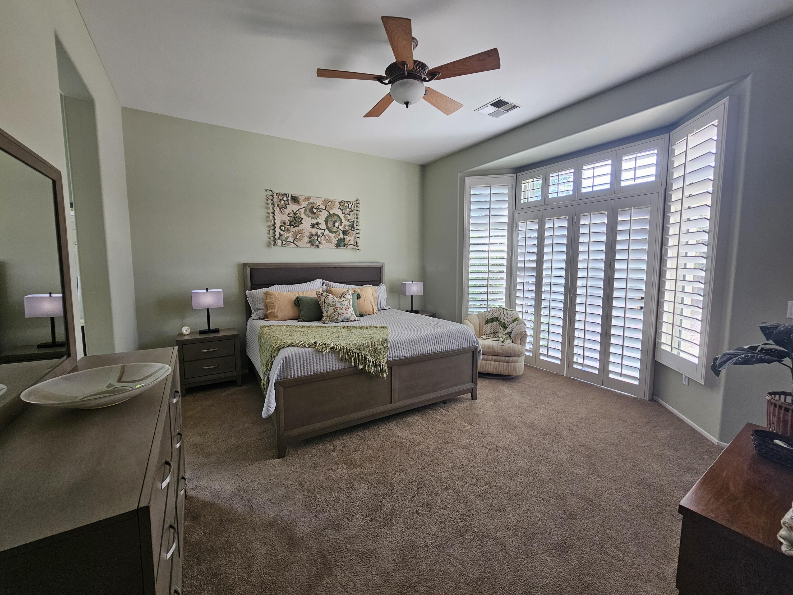35875 Donny Circle Palm Desert, CA 92211 - Photo 18 of 50 a spacious bedroom with a bed a couch and a large window