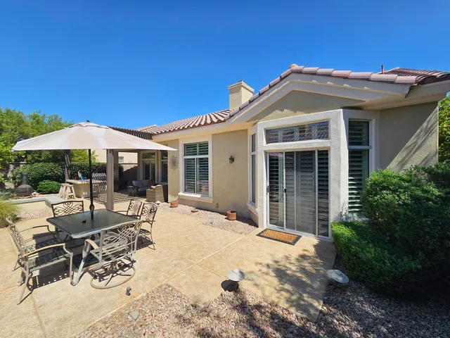 a view of a house with backyard and sitting area