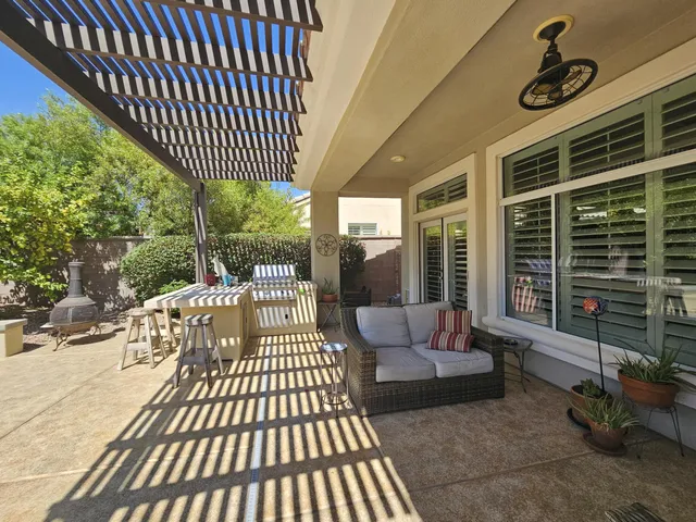 a view of a patio with couches table and chairs and potted plants