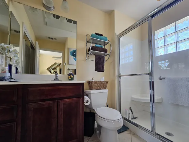 a bathroom with a sink a toilet a mirror and shower