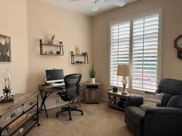 a view of a livingroom with workspace and a window