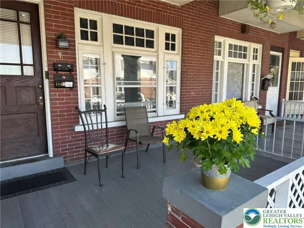 a vase of flowers sitting on a table in front of a house